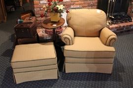 Club chair with ottoman, tilt top table and vintage luggage.