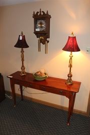 Small table, pair of lamps and clock.