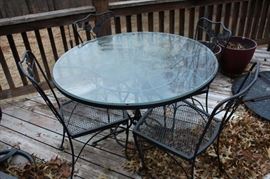 Glass top round patio table with four chairs.