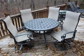 Basket weave patio table with four swivel chairs.