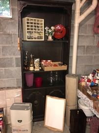 Another cabinet displaying decorative items. Paper shredder in front