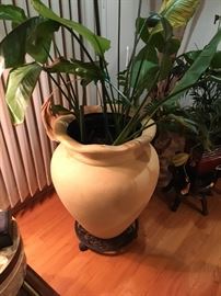 Oversized flower pot with plant and "roll stand." 
