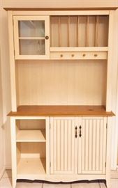 Off-white Hutch stores plates on top and  cups or towels from the top knobs. Lower storage too.
