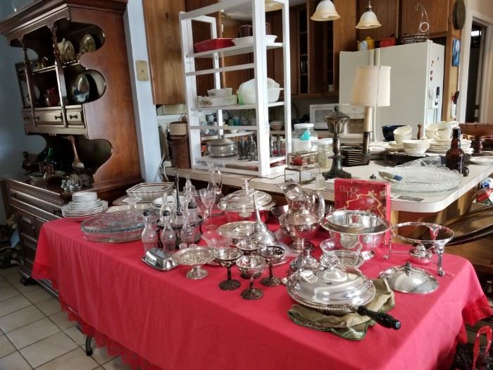  A table full of dishes, plated silver serving pieces and more