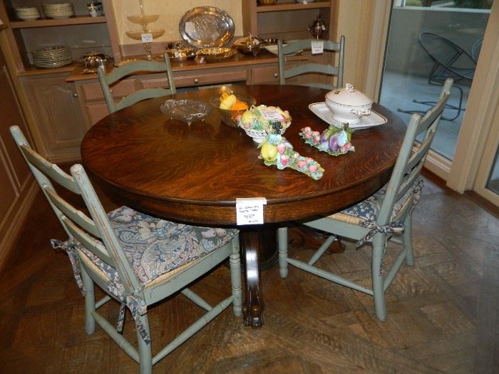 Carved foot single pedestal oak dining table with six painted rush seat chairs.