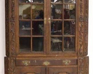 Eagle adorned carved corner cupboard
