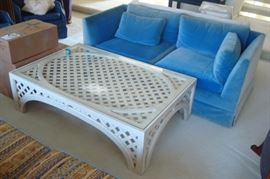 Blue velvet loveseat and glass top coffee table.