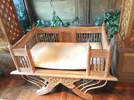 One of two carved wood gallery chairs with cushions.