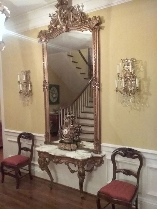 French Pier Mirror with rich ornamentation in the cornucopia floral and torchee motifs accompanied with the marble top table.