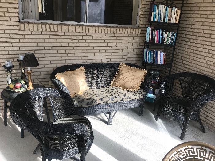 A sunporch filled with black wicker furniture