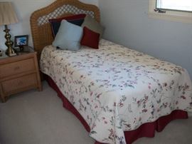 One of the two twin beds by HENRY LINK. Linens and quilts are for sale also.
