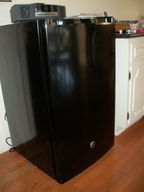 Small, black refrigerator with small freezer.