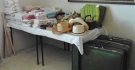 Suitcases and linens and hats and caps