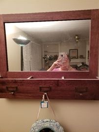 Brown wood hanging mirror with 3 compartments and brass ID plates with brass hooks.