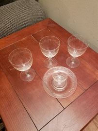 Set of vintage crystal wine glasses, dessert plates and small glasses for liquor or ice cream.