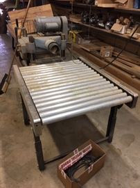 This is the Vintage Rockwell-Invicta Delta 22-650 Planer  sitting behind one of the conveyor tables. This machine (made in Brazil) gets great reviews online. They don't make'em like they used to!