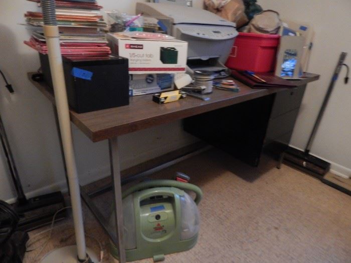 Another table/desk. Copier, office supplies and a Bissell carpet/upholstery  cleaner.