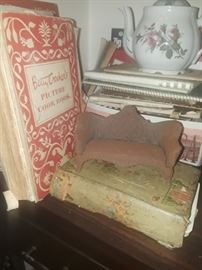 Cookbooks, the green one is very old. Moss rose teapot. There is also a childs set. Little wrought iron couch, nice pantina. 