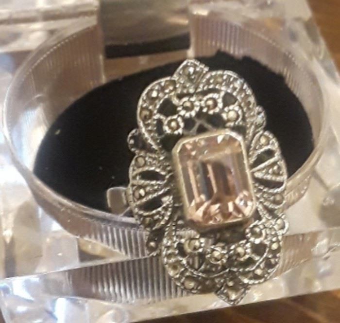 Pretty sterling silver ring, with oversized emerald cut  pink cz. The marcasites (there are a couple missing) make this piece sparkly. It has been professionally cleaned. 
