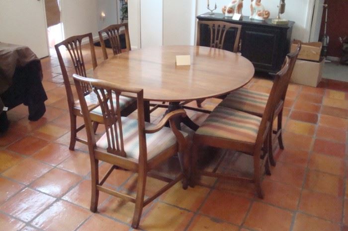 Elegant Baker Vintage Duncan Phyfe style dining table with three leaves, and set of six Biggs Hepplewhite style mahogany chairs.