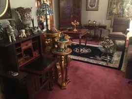 Wool area rug, gold plant stand, upholstered wing back chair, vintage wood with glass top coffee table