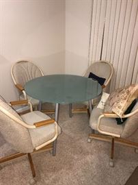 GLASS ROUND TABLE AND 4 ROLLING CHAIRS