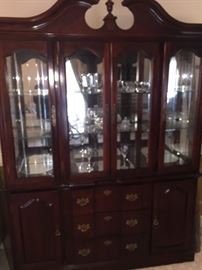 lighted china cabinet that is filled with higher end crystal