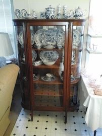 Antique oak china cabinet with curved glass.