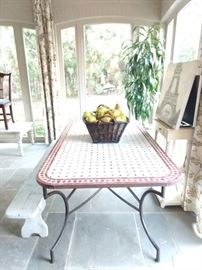 Bring artistic color to your  décor with this  rectangular metal outdoor bistro patio table with hand-laid red and white tiles. Made with legs of durable tubular steel, it boasts a top of hand-laid tiles. Its artful design is complemented by a black powder coat finish that keeps it looking good all season long. Keeping it clean is easy too, just hose it down and let the warmth of the sun dry it off. Enjoy a morning cup of your favorite brew or a glass of wine with a friend on this delightful table.  Basket of French pears perfectly compliments the mood!