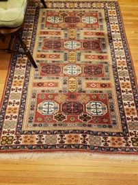 Wool area rug 72" x 48". Assorted geometrics in shades of cream, mustard, cinnabar, red and blue.