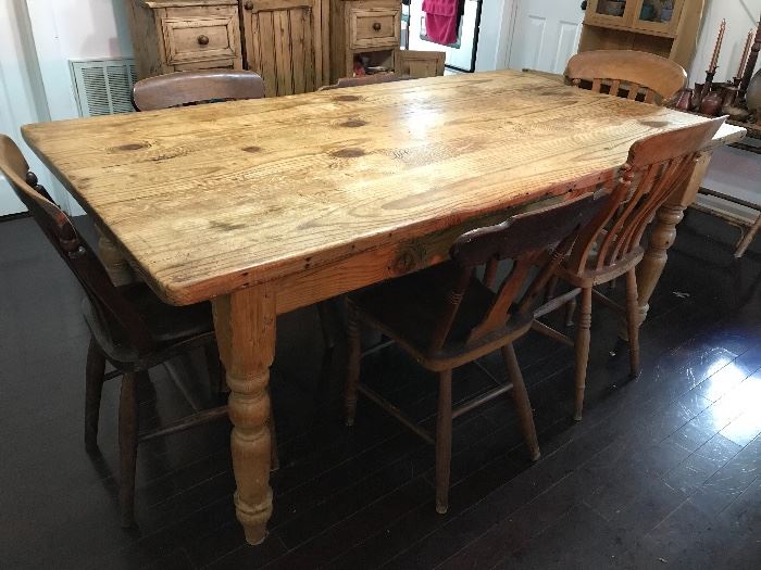 Large antique English country pine dining table with mismatched chairs.