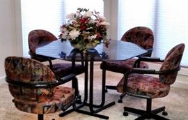 Black Metal Dinette set with Octagonal Smoked glass Top and 4 Colorful Upholstered Chairs on castors