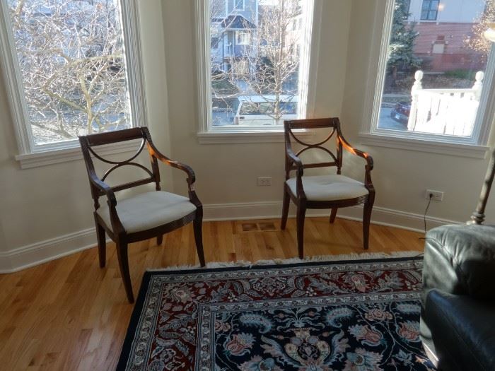 Two living room side chairs, dark wood, and cream cushions. Could stand to be reupholstered. Size: 1'10" wide x 1'7" deep x 2'10" tall at the top. Pretty good condition.