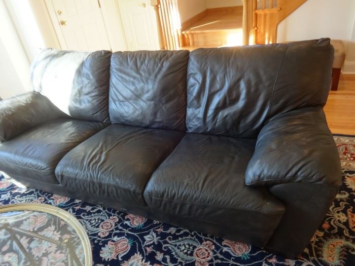 Large black leather living or family room sofa; extremely comfortable to sit or sleep on. Size: 7 1/2' long x 3' tall x 3'2" deep. Heavy, heavy piece. Good condition. Some pet claw marks, but no rips.