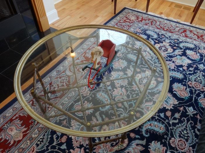 Glass top coffee table bordered in brass, top lifts off of the brass base. Size: 3'2" diameter x 1'6" tall. Glass is heavy, base is not.