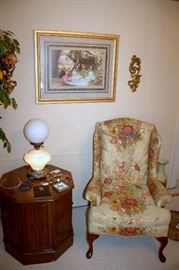 Upholstered wingback armchair, end table, framed print