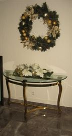 Foyer table, heavy brass base & glass top, wreath