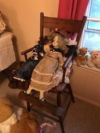 Porcelain dolls sitting in oak young chair