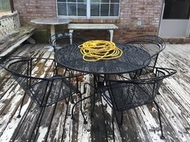 Another black wrought iron table with 4 chairs