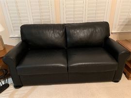 Custom black leather sleeper sofa in like-new condition.    Rarely used and only slept on one time. 