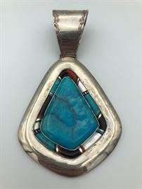 Item Number P73. Client paid $699 (tag says MDO). Unsigned. Large turquoise with multi-stone inlay around the main stone. Measures 5" from the top to the bottom. Turquoise measures just over 2" from top to bottom. 