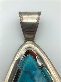 Item Number P73. Client paid $699 (tag says MDO). Unsigned. Large turquoise with multi-stone inlay around the main stone. Measures 5" from the top to the bottom. Turquoise measures just over 2" from top to bottom. 