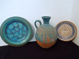 Lot 268: Three 70's Studio Pottery Pieces from Charles Counts and Rising Fawn.
Two pieces are signed by Charles Counts: the 8" ovoid handled jug and the blue and grey 5.5" dish with "inner flame" scored design. The 7.5" turquoise and peacock blue colored plate with fish scale design is etched "Rising Fawn" on the back. Rising Fawn is the name of the arts community outside of Lookout Mtn., TN. The pieces are very fine examples from the 1970's with beautiful glazing. No cracks, chips or kiln errors noted. Fish scale blue plate marked Rising Fawn is slightly warped. Charles Counts (1934–2000) was an American potter, designer, textile artist, quilter, teacher, writer, and activist. Counts worked to preserve the art forms of his native Appalachia, and produced and sold at Rising Fawn and Plum Nelly Clothesline Art Show.