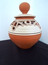 Lot 274: 1970's Studio Pottery Terracotta Covered Ovoid Vessel
Banded and cut out southwest and deco inspired covered ovoid pot with ball handle lid. Lowfire terracotta. Do not recognize potter's signature, but believe it to be a southern artist from the 1970's. No chips, cracks or kiln issues. Has residue from pads on bottom. From living estate of Charles Rathbun.