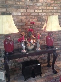 Sofa table and pair of fine looking red lamps; each shade has tassels