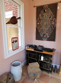 Hand hooked antique rug on wall, Fireplace bellows with copper trim in window, Wooden butter churn, cast iron galore (Mostly Griswold & some Wagner)