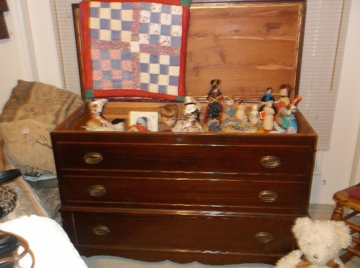 Mahogany cedar chest, doll collection, and handmade quilt