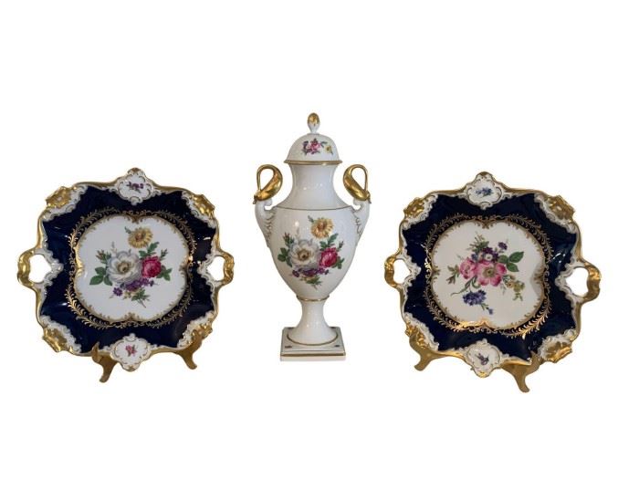 Porcelain Collection by Kaiser, Germany. Set of three porcelain decorative grouping. One Vase and two matching decor platters with handles. The floral design on the plates are represented on each side of the Urn. Beautiful detail and design.