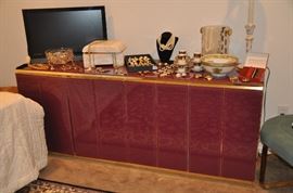 Vintage custom made cranberry colored lacquer 6 drawer dresser/sideboard with polished brass trim, 72"w x 29"h x 20"d. Shown with a 26" flat screen TV, Lalique-style ice bucket, vintage Hammersley demitasse cups, tons of jewelry and so much more!