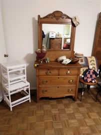 One of two, solid wood dressers with mirror; white wicker.